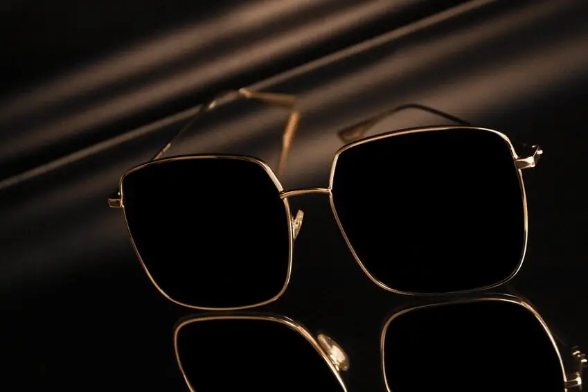 Accessori di Lusso Uomo, occhiali da sole con le lenti scure, in un ambiente neutro.